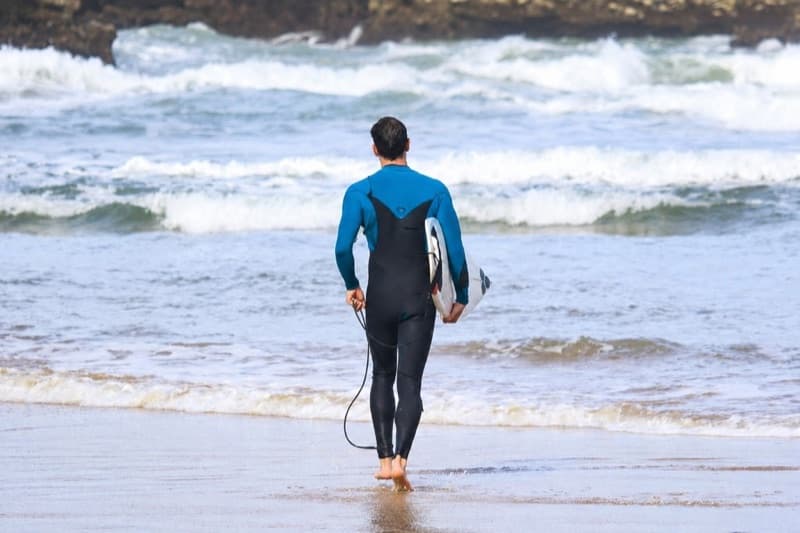 Lucas marchant vers l'océan avec sa planche de surf